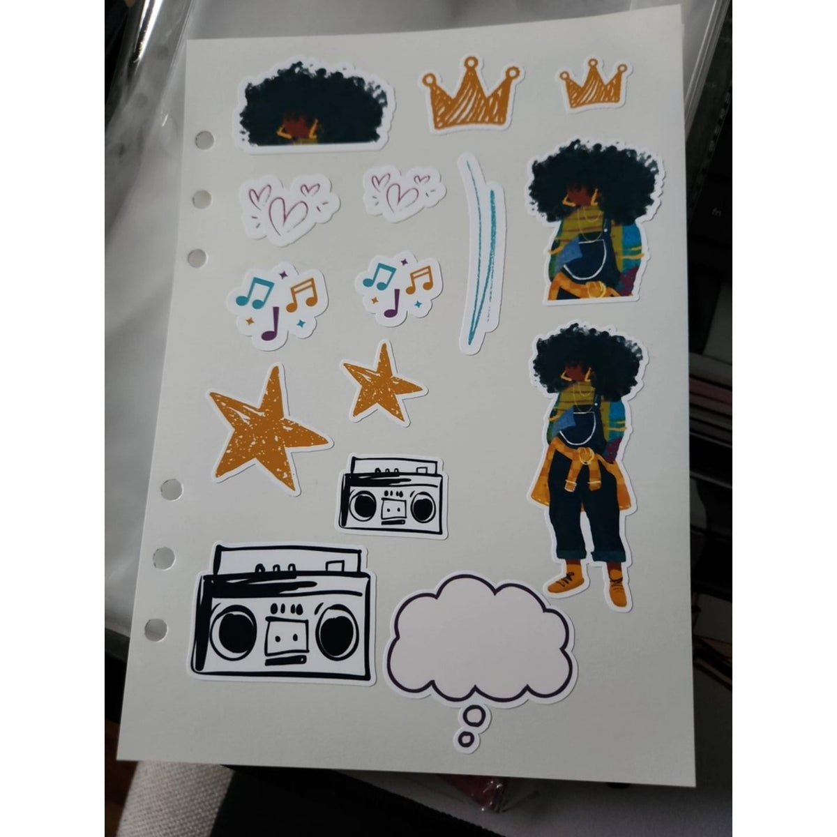 Close-up of JJ journal and planner sticker sheet with colorful character and 90s-inspired icons